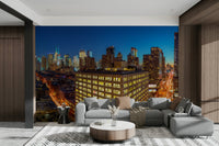 The image shows a full wall with glowing buildings and city lights.

