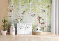 Birchwood Forest Friends Tales wallpaper mural of birch trees and a deer behind a white toy chest and giraffe storage in a nursery