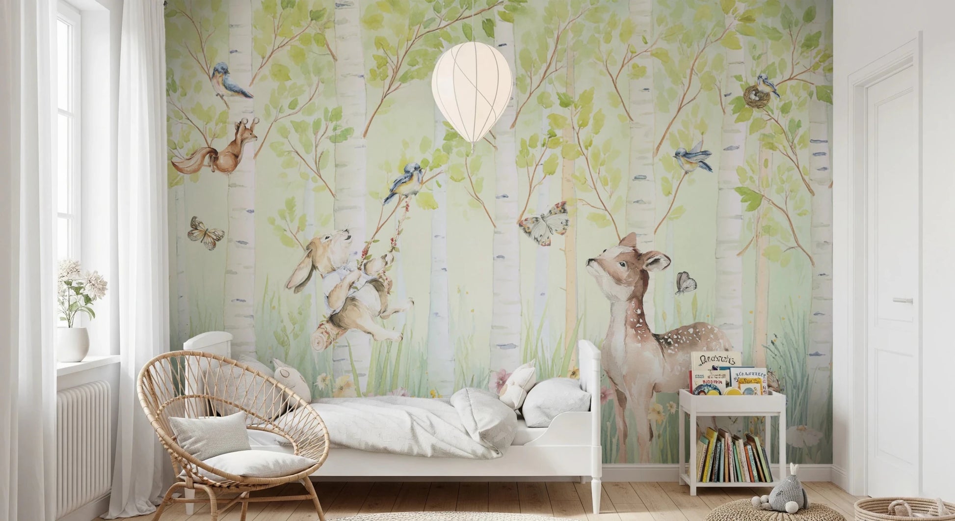 Birchwood Forest Friends Tales wallpaper mural of birch trees and a deer behind a white bed and rattan chair in a nursery