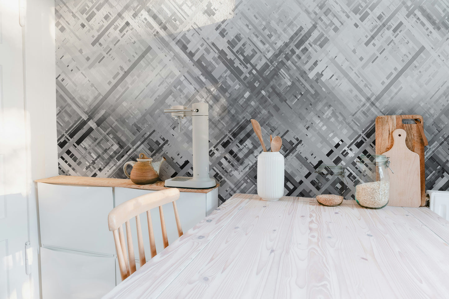 Abstract Diagonal Lines wallpaper mural in grey above white cabinets and a wood counter in a bright kitchen
