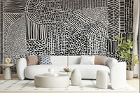 Black And White Maze wallpaper mural behind a white curved boucle sofa and round tables