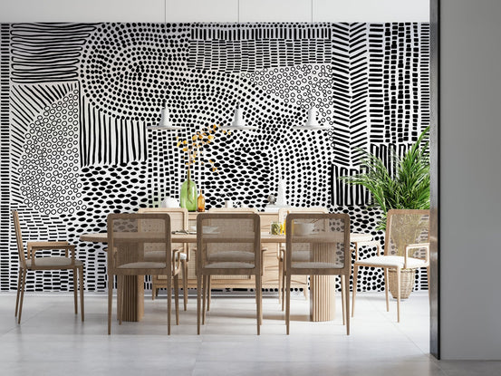 Black And White Maze wallpaper mural behind a wood dining table and cane chairs in a bright room