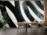 Black Brush Stroke wallpaper mural of black swirling brushstrokes on white in a dining room with wood table and tall palm