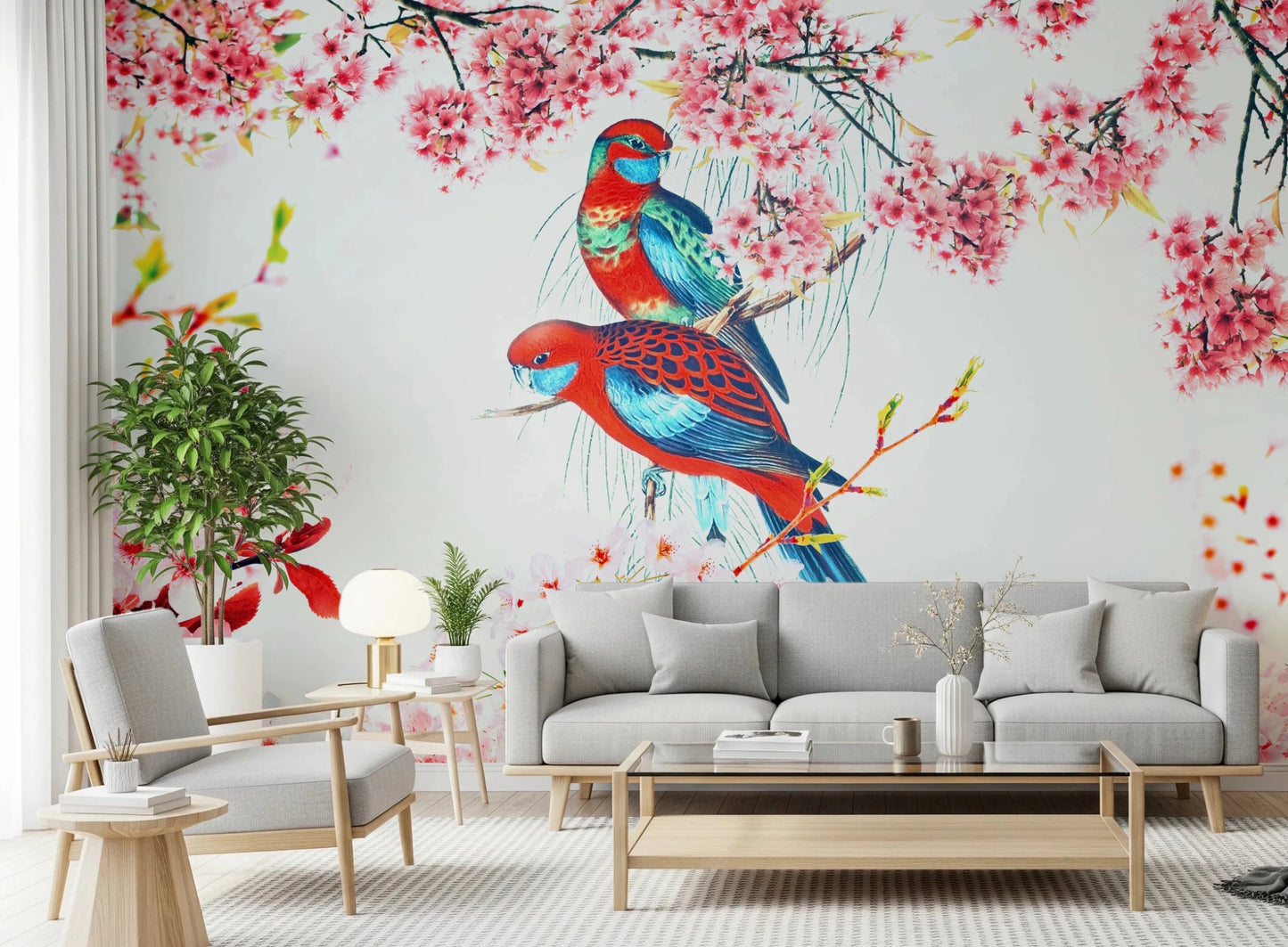 Blossom Birds wallpaper mural with red and blue parrots behind a grey sofa and wood armchair in a living room
