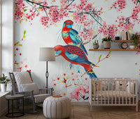 Blossom Birds wallpaper mural of parrots and cherry blossoms behind a white crib and rocking chair in a nursery
