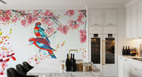 Blossom Birds wallpaper mural of parrots and pink flowers behind a white marble kitchen island and bar stools