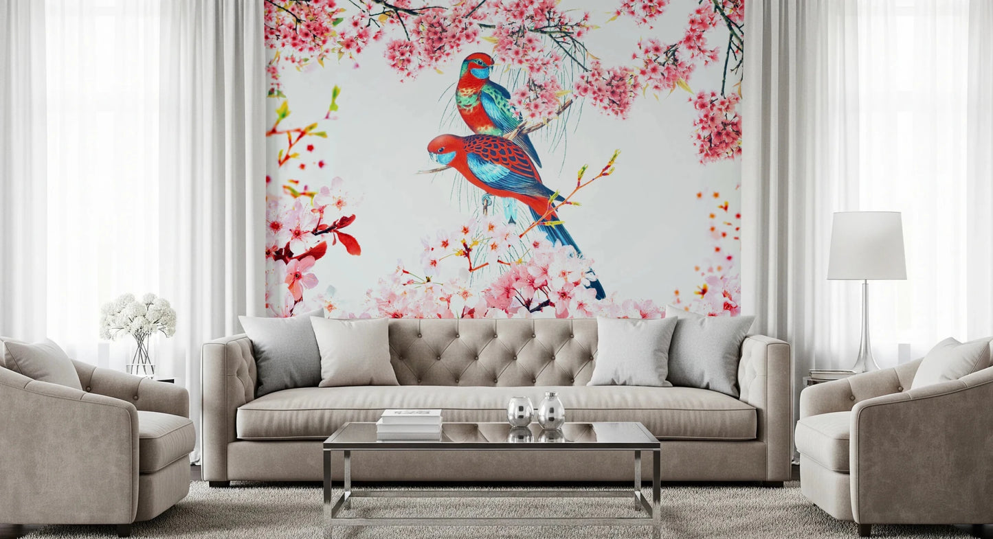 Blossom Birds wallpaper mural with red and teal parrots and pink blossoms behind a beige tufted sofa