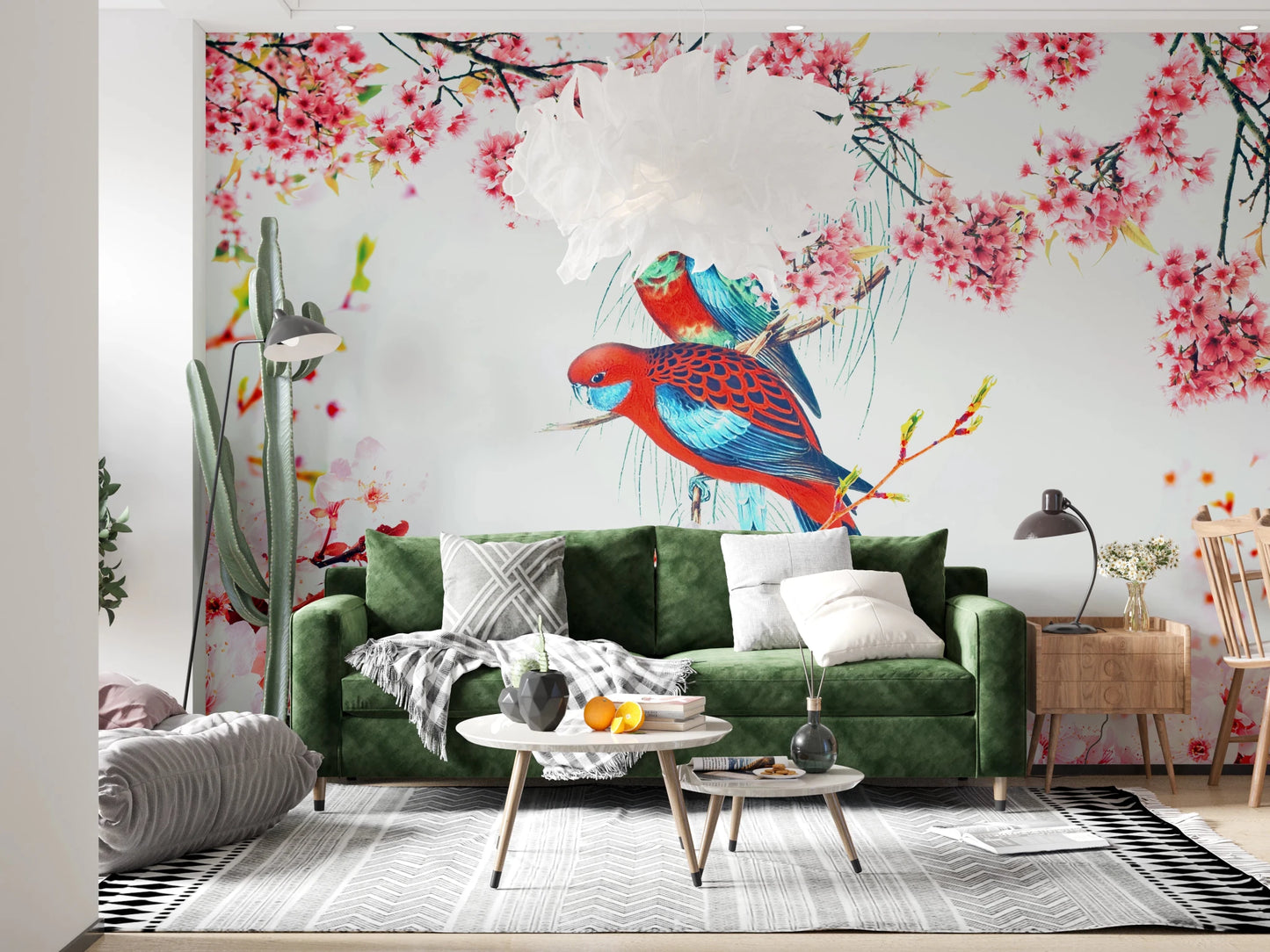 Blossom Birds wallpaper mural of parrots and blossoms behind a green velvet sofa with a tall cactus