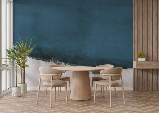 Blue Brushstrokes wallpaper in deep navy with a white painterly band behind a round wood dining table in a dining room