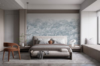 Blue Buttonwood Tree wallpaper mural of a soft grey-blue forest treeline behind a beige bed in a calm bedroom