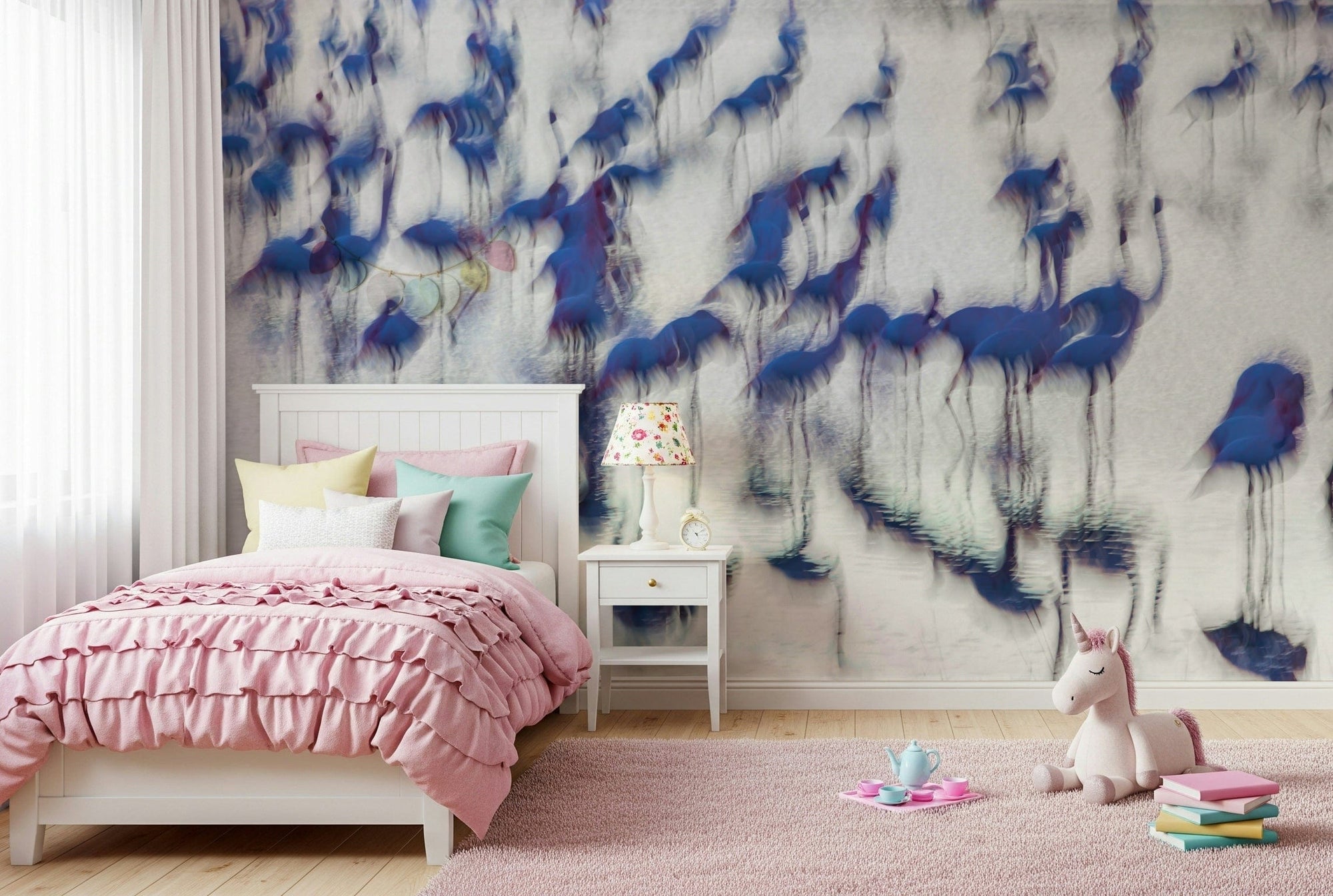 Flamingo Mirage wallpaper mural of abstract blue flamingos behind a white bed with pink ruffled bedding in a girls room