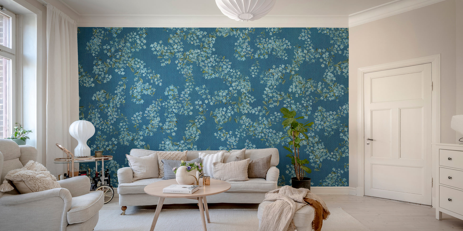 Blue Floral peel and stick wallpaper in blue with white blooms behind a cream sofa and armchairs in a living room