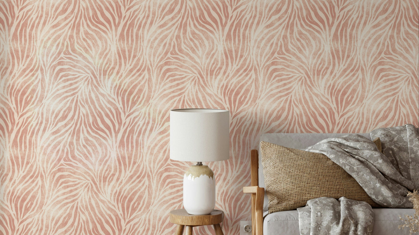 Blush Zebra Stripes wallpaper in a bedroom with a white lamp on a wood stool and a grey bed with throw