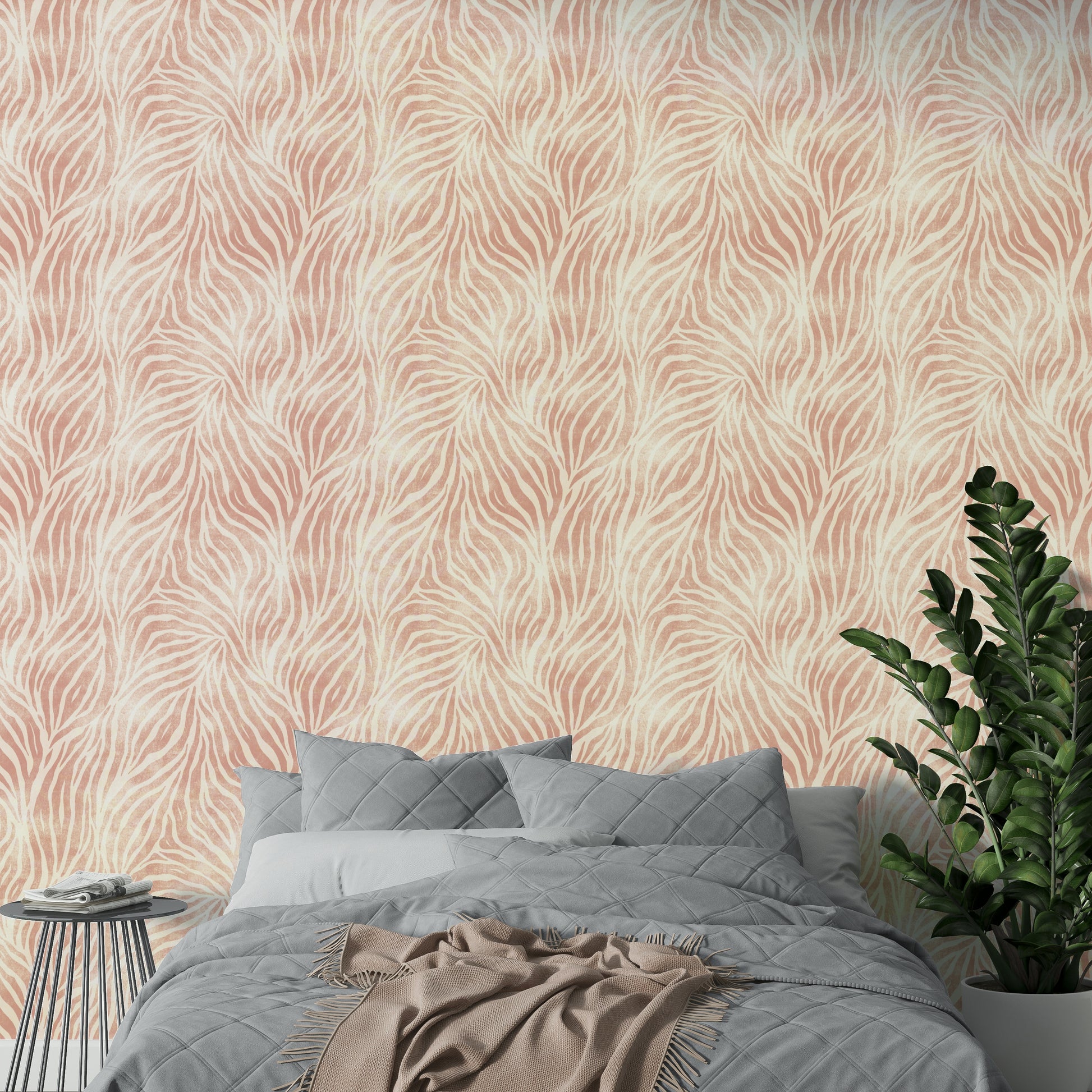 Blush Zebra Stripes wallpaper in a bedroom with grey quilted bedding, a blush throw and green fern