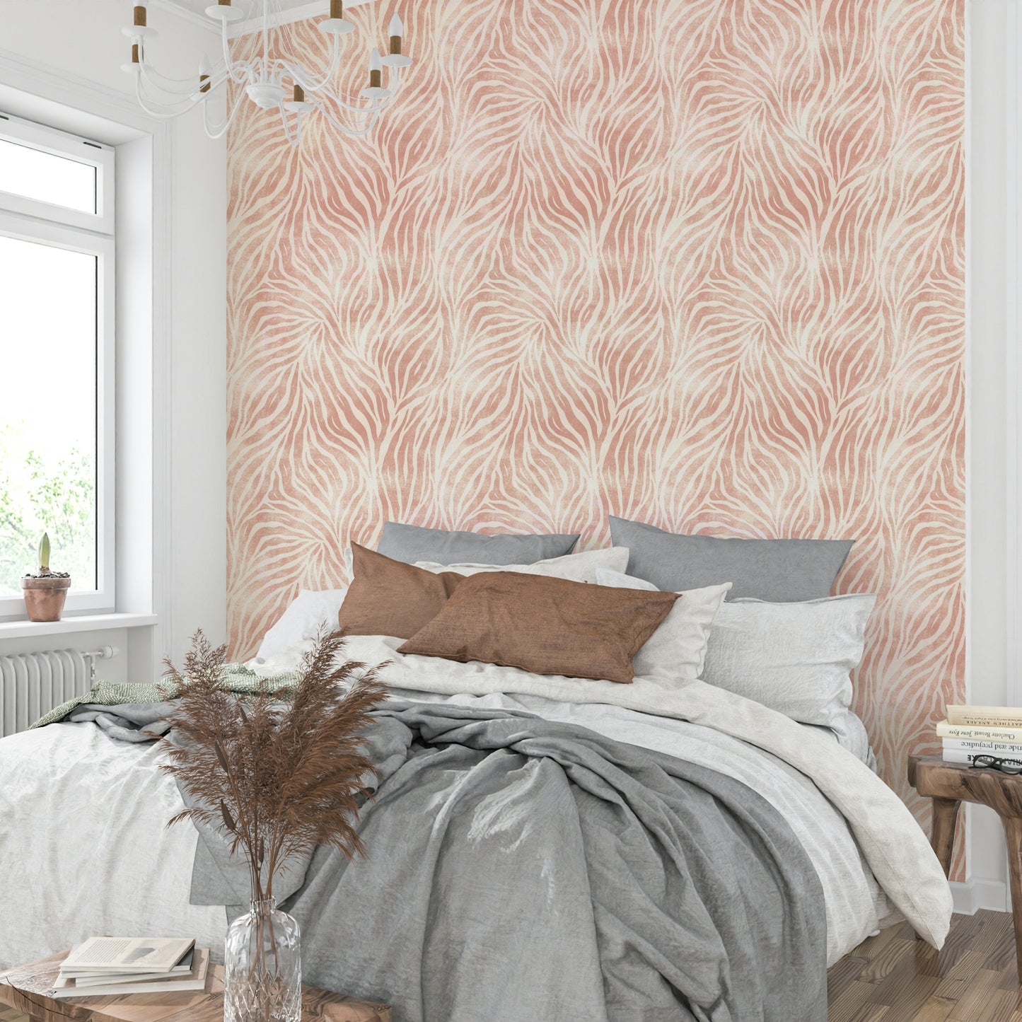 Blush Zebra Stripes wallpaper in a bedroom with a white chandelier, grey pillows and pampas grass