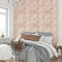 Blush Zebra Stripes wallpaper in a bedroom with a white chandelier, grey pillows and pampas grass