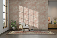 Blush Zebra Stripes wallpaper in an entryway with a rattan armchair, red rug and leafy plant in sunlight