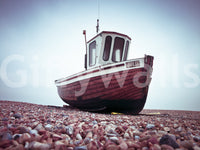 Boat Resting on Pebbled Strand, dark wooden vessel, rocky ground, wall covering.