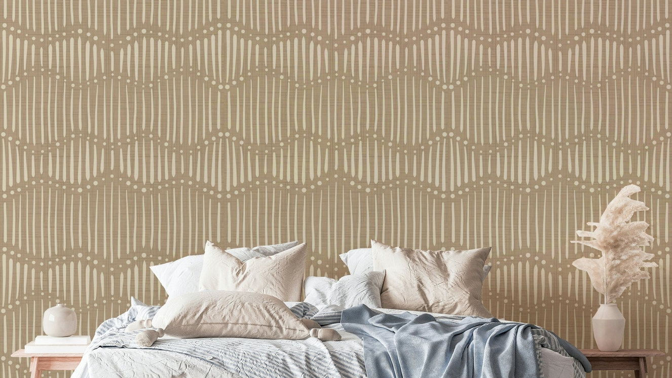 The mural is installed in a calm, bohemian living room behind a simple, light-colored sofa.

