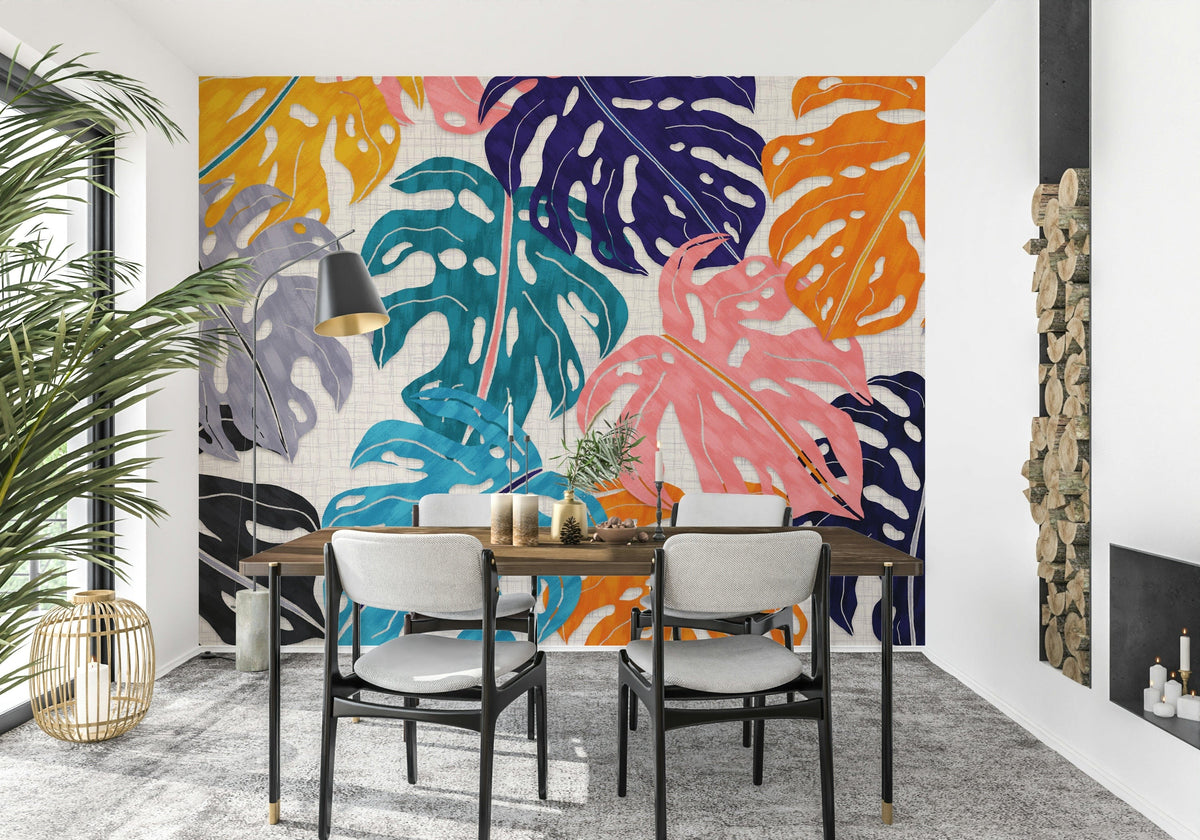Colorful Bold Monstera Leaves wallpaper mural behind a wood dining table and grey chairs in a dining room
