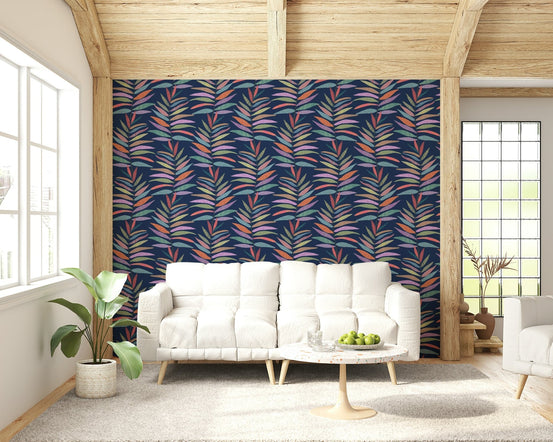 Botanical Groove wallpaper of colorful leaf fronds on navy behind a white sofa under a wood-beam ceiling