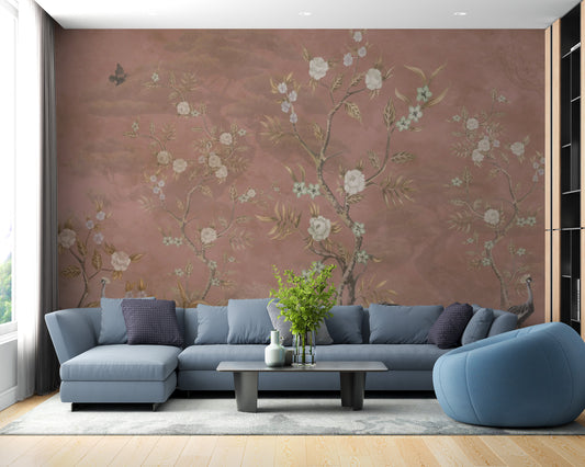 Brown Chinoiserie wallpaper with white blossoms on a terracotta wall behind a blue sectional sofa in a living room