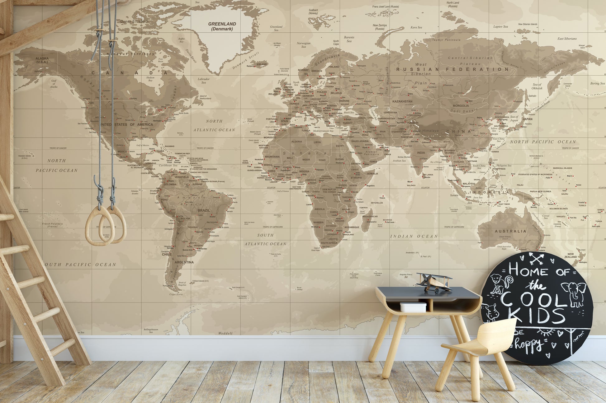 Brown Detailed Worldmap wall mural in beige tones behind gym rings and a small play table in a kids playroom