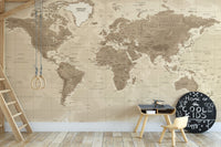 Brown Detailed Worldmap wall mural in beige tones behind gym rings and a small play table in a kids playroom