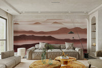 Burgundy Mountain Haze wallpaper of dusty-rose layered peaks behind a large beige sofa and live-edge wood tables