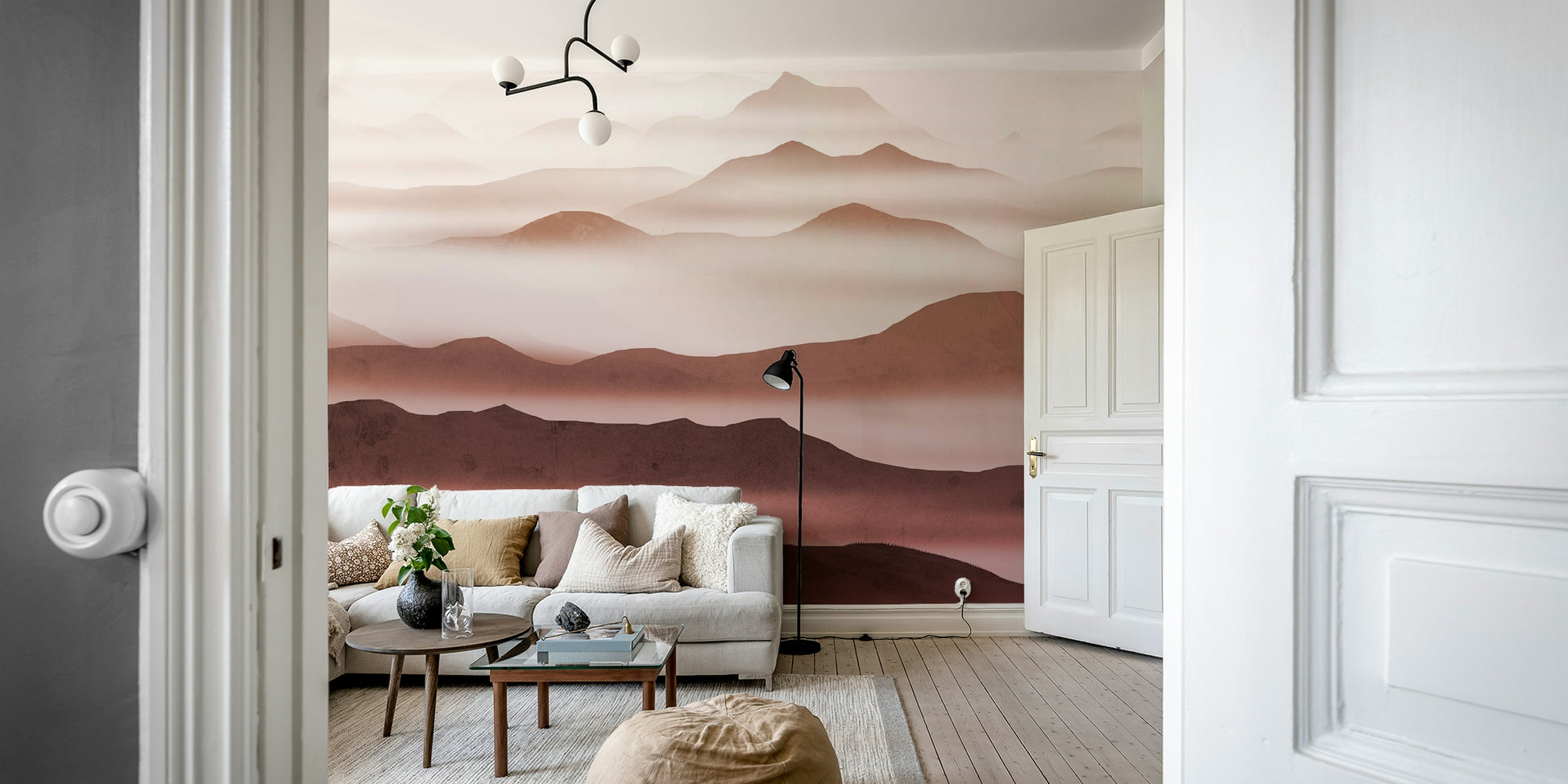 Burgundy Mountain Haze wallpaper of layered rose mountains seen through a doorway behind a white sofa and floor lamp