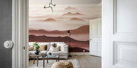 Burgundy Mountain Haze wallpaper of layered rose mountains seen through a doorway behind a white sofa and floor lamp