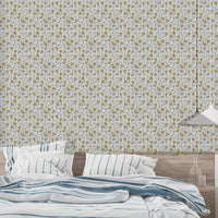Buttercups Garden Golden and Gray wallpaper over a bed with blue-striped bedding in a bedroom