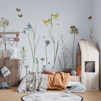 Butterfly Garden wallpaper mural of wildflowers and butterflies in a kids bedroom with a wooden house-frame bed and toys