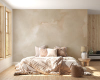 Abstract Beige Watercolor wallpaper mural of warm beige wash behind a boho bed with chunky knit bedding in a sunny bedroom