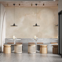 Abstract Beige Watercolor wallpaper mural of muted cream wash behind white bistro tables and rattan stools in a cafe