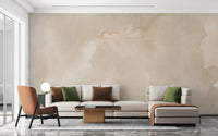 Abstract Beige Watercolor wallpaper mural of soft cream wash behind a beige sofa and rust accent chair in a living room