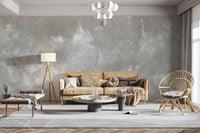 Baltic Sand Textured Abstract wallpaper mural in grey behind a camel sofa, tripod lamp and rattan chair in a living room