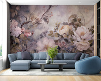 Barok Blossom Pink Color wallpaper with soft painterly peonies behind a blue sectional sofa in a living room