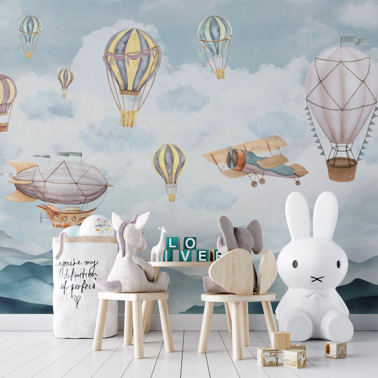 Cloud Drifter Airships Wall mural of pastel balloons in a kids room with wooden chairs and a bunny lamp