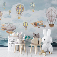 Cloud Drifter Airships Wall mural of pastel balloons in a kids room with wooden chairs and a bunny lamp