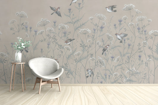 Enchanted Aviary Ballet mural of beige wildflowers and birds behind a white egg chair in a living room