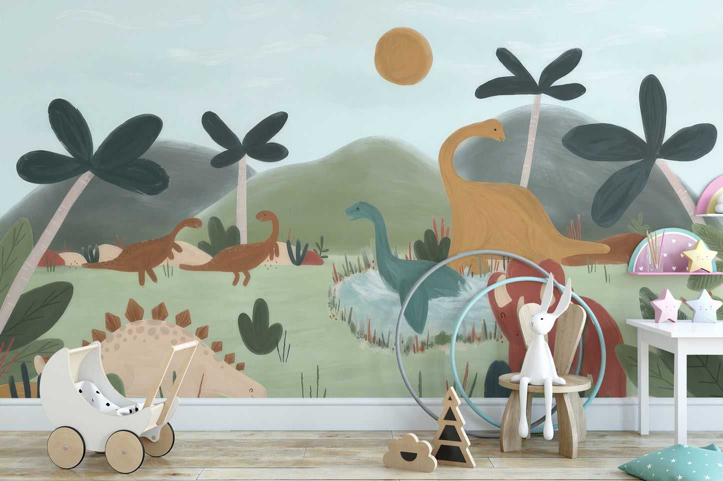 Gentle Giants dinosaur wallpaper mural behind a white toy pram and wooden bunny stool in a soft nursery