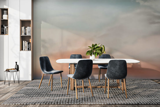 Sunset Dreams wall mural with soft coral and sage sky behind a marble dining table and dark chairs