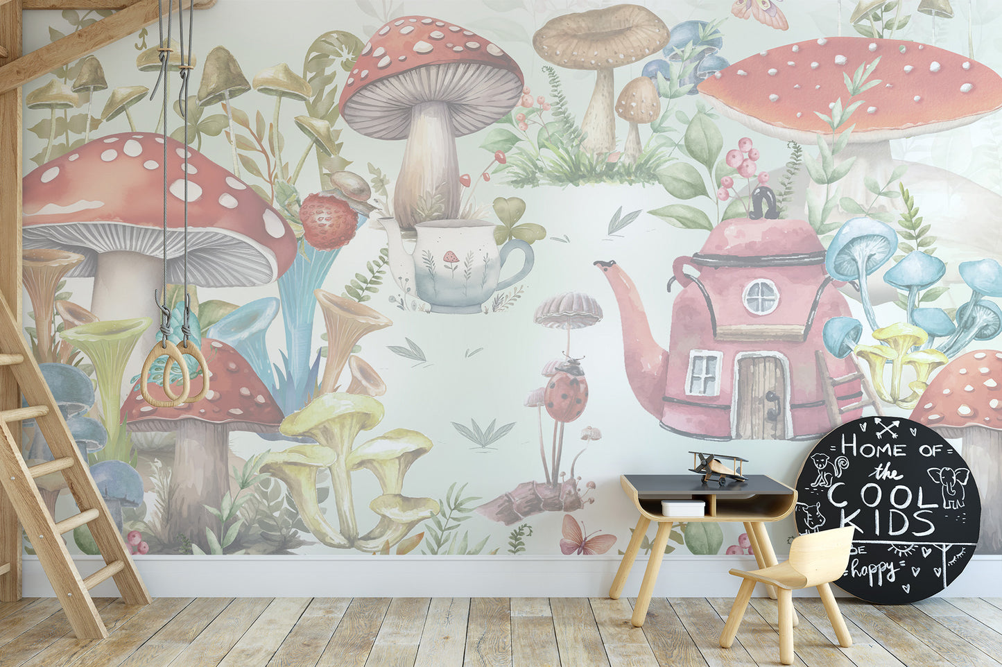 Whimsical Mushroom Garden wallpaper mural with toadstools and a pink teapot cottage behind a black play desk in a kids room