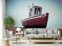 Vintage Boat Resting on Pebbled Strand wallpaper for walls, maroon hull, shingle.