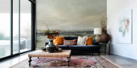 Coastal Hues wallpaper mural of a green coast behind a navy sofa with orange cushions in a living room