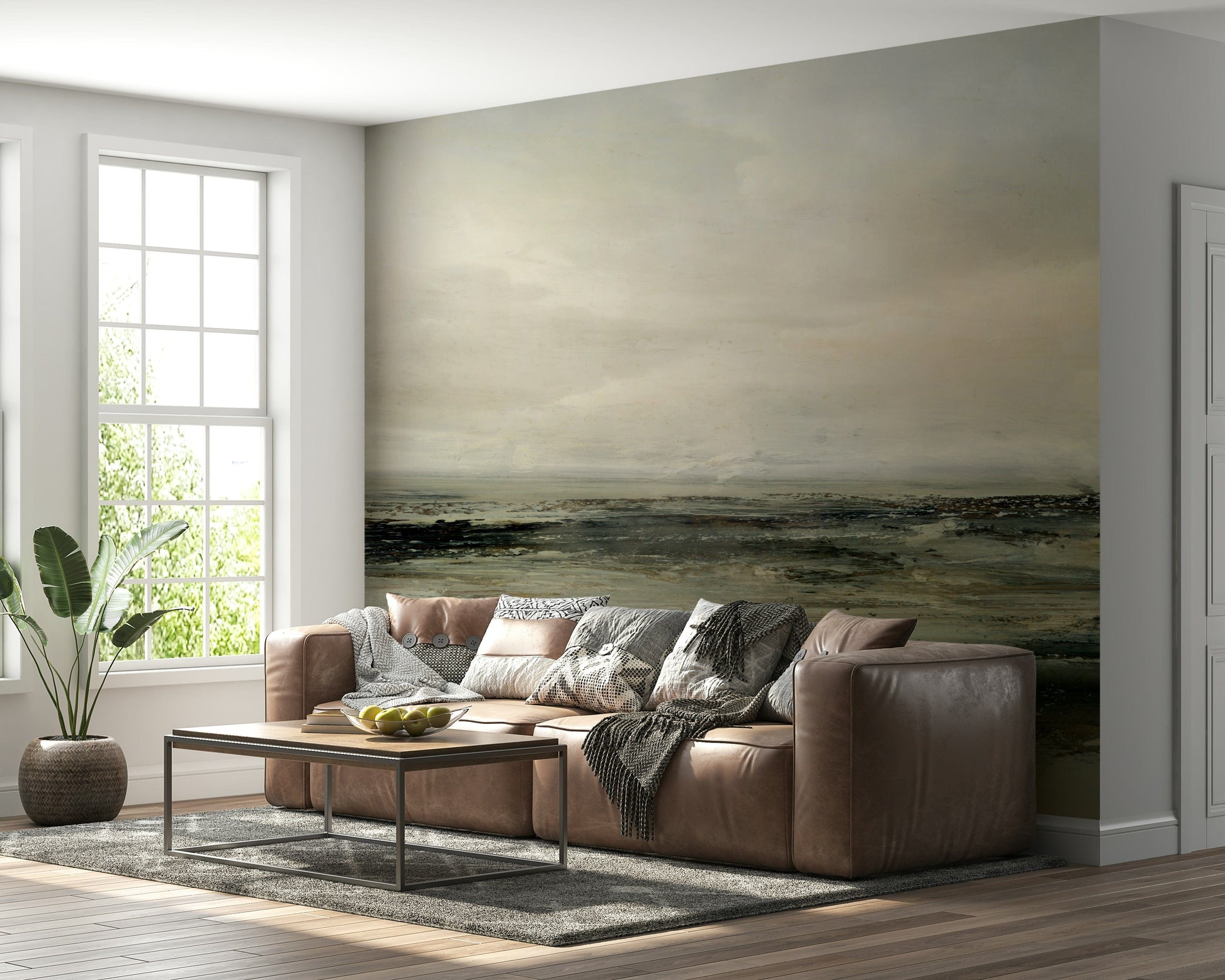Coastal Hues wallpaper mural of an olive and brown shore behind a brown leather sectional sofa in a living room