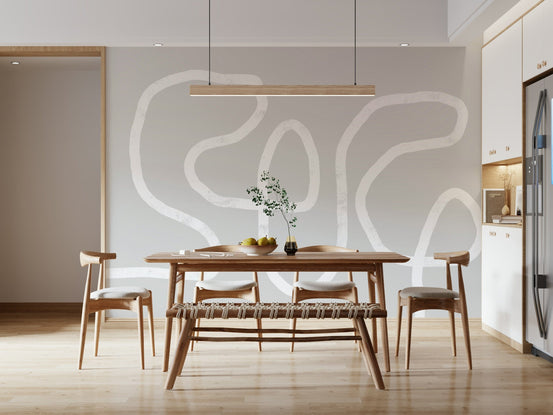 Simple Curves wallpaper mural with white abstract line squiggles on grey behind a wood dining table and woven bench