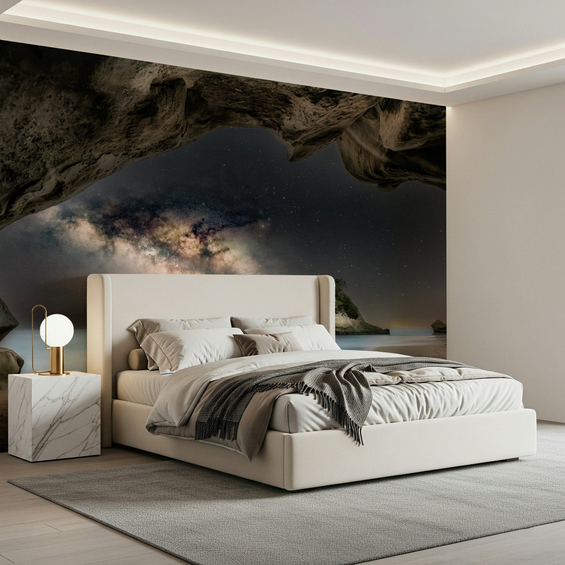 Cave Portal to Starlight wallpaper mural of a glowing galaxy in a sea cave above a cream bed in a modern bedroom