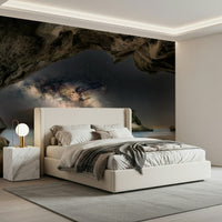 Cave Portal to Starlight wallpaper mural of a glowing galaxy in a sea cave above a cream bed in a modern bedroom